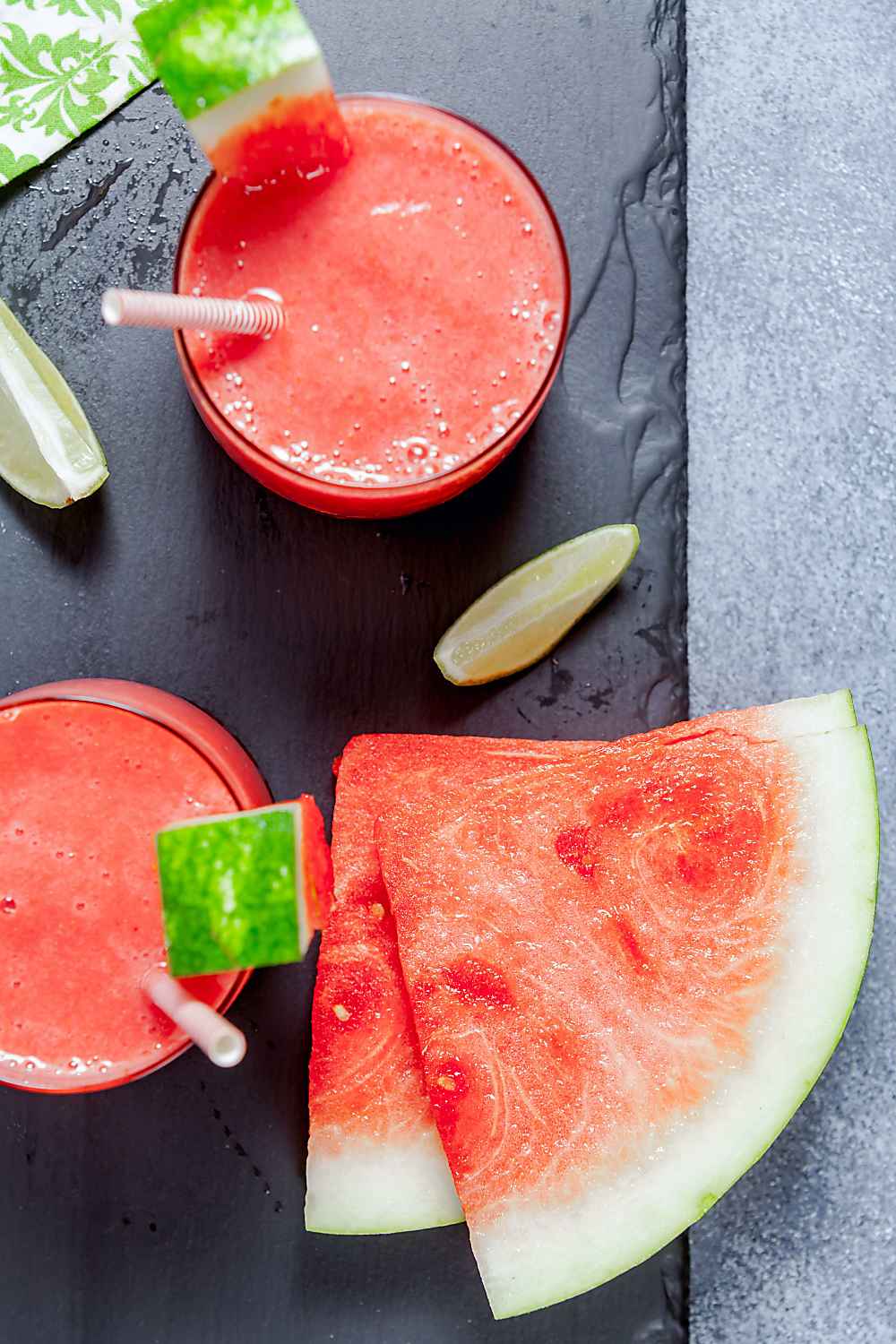 Dairy-free watermelon smoothies ready for serving, garnished with fresh watermelon sliced and limes. 