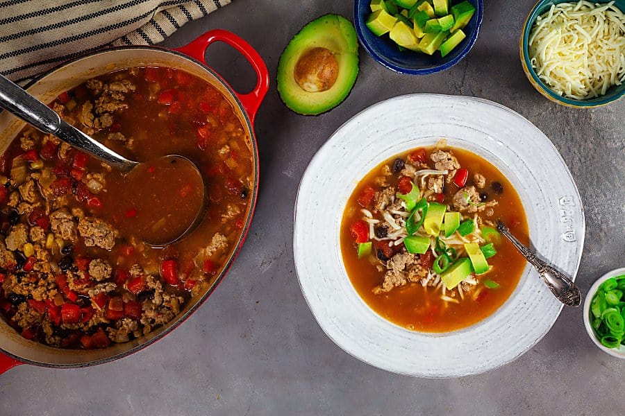 enchilada soup with avocado and green onions