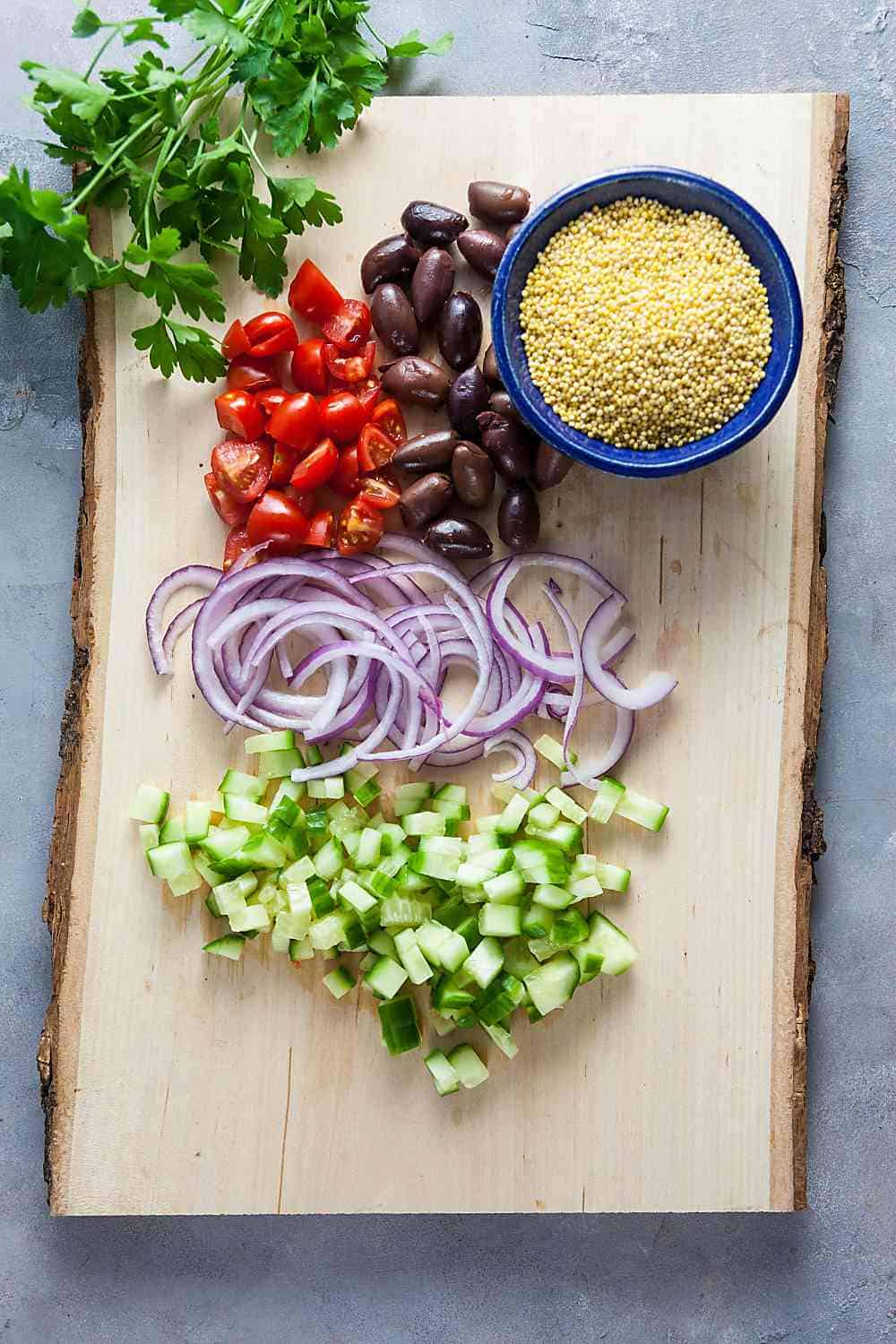 ingredients for Greek Millet Chicken Salad on a cutting oard
