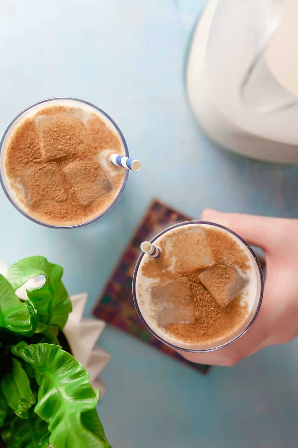 overhead photo of two glasses of horchata topped with cinnamon