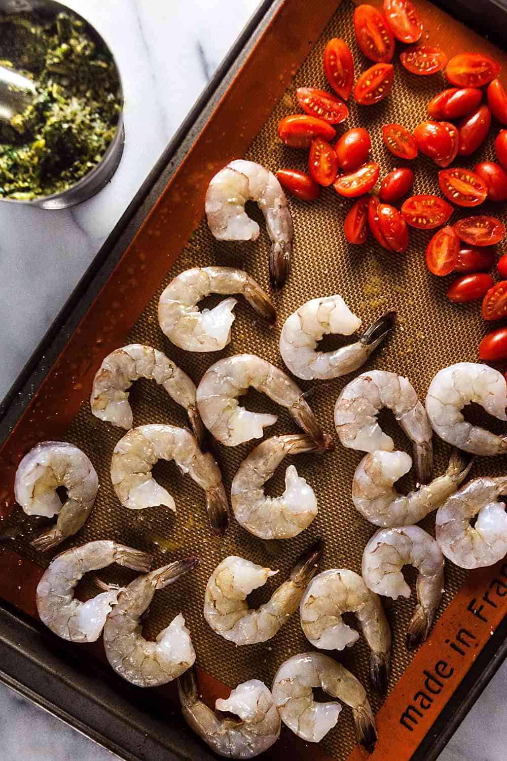 shrimp and tomatoes on a baking sheet
