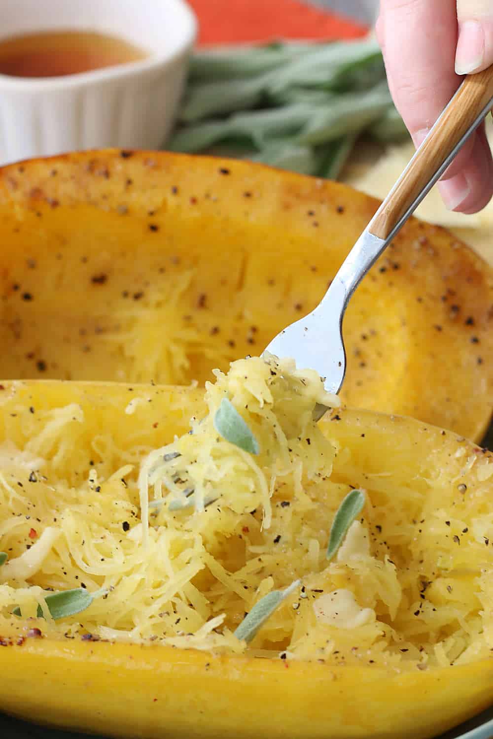 Finished spaghetti squash with seasonings and toppings on a platter ready to be topped and enjoyed. 