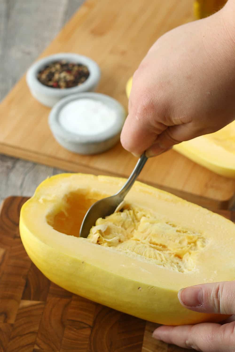The first step for how to cook spaghetti squash in the oven is scraping out the seeds! 