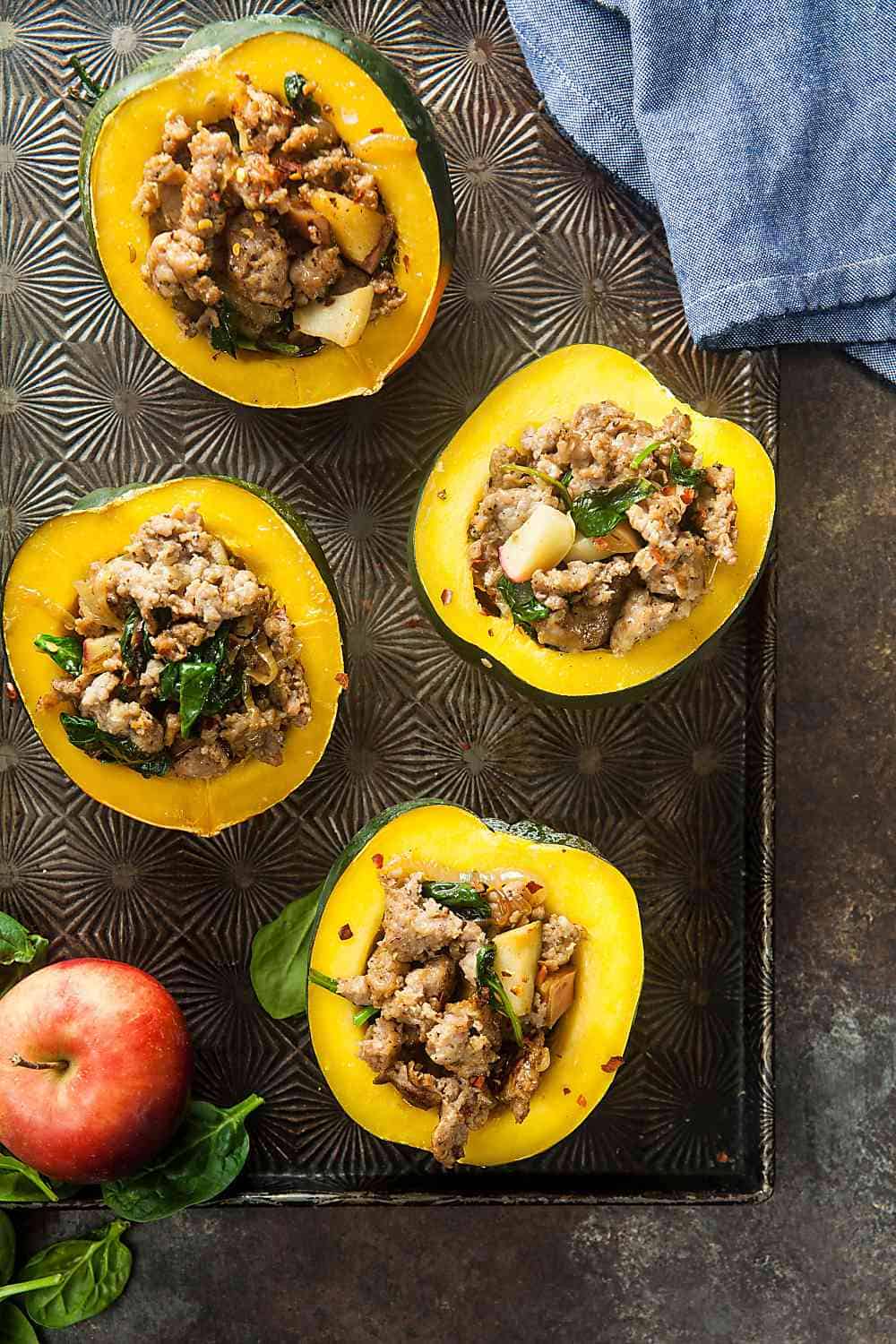 A tray of stuffed acorn squash with sausage and apples