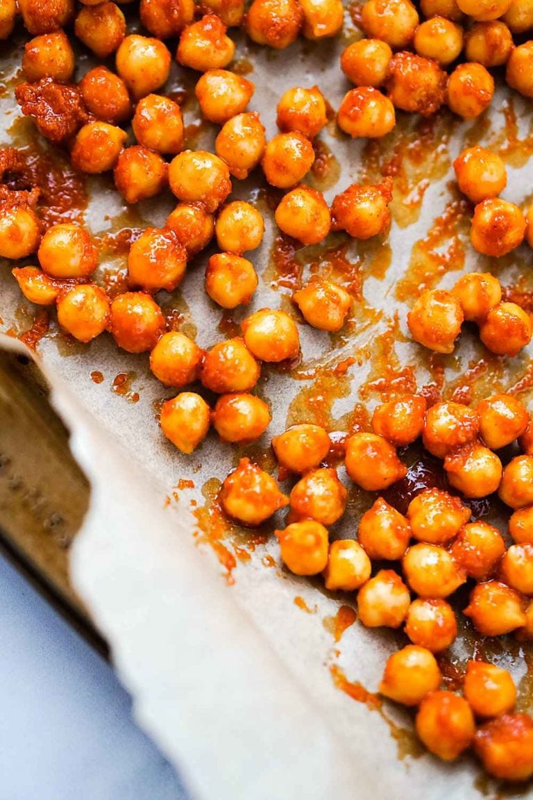 buffalo sauce and spices on chickpeas, ready to be baes until they're crispy and crunchy