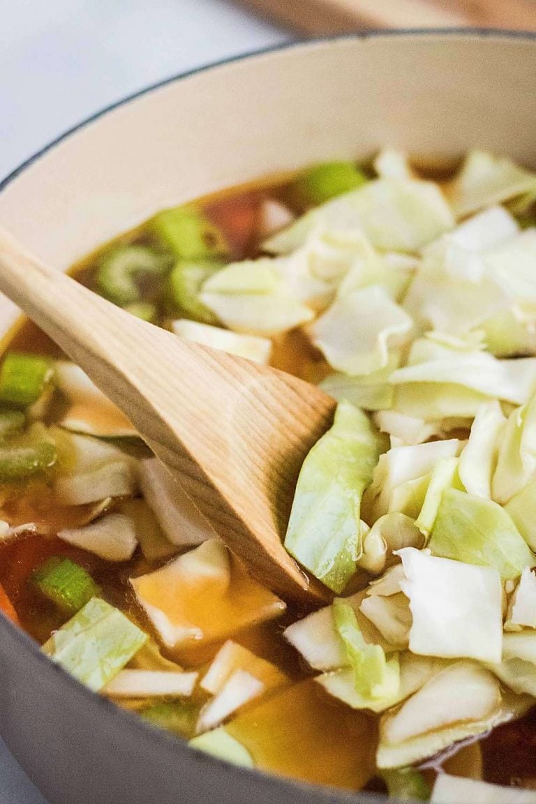 Stirring cabbage into vegetable soup