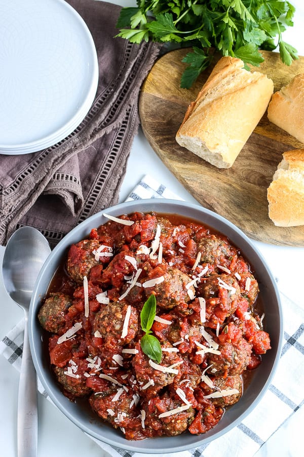 overhead view of meatballs in a bowl with bread next to them