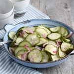 landscape image of cucumber salad in a bowl