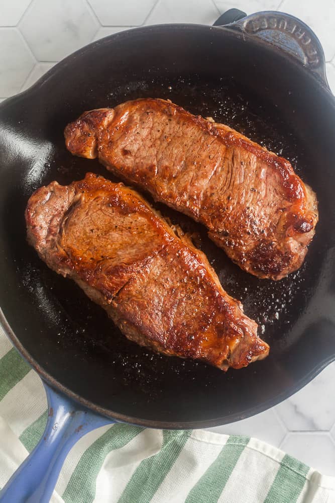 two seared steaks in a pan