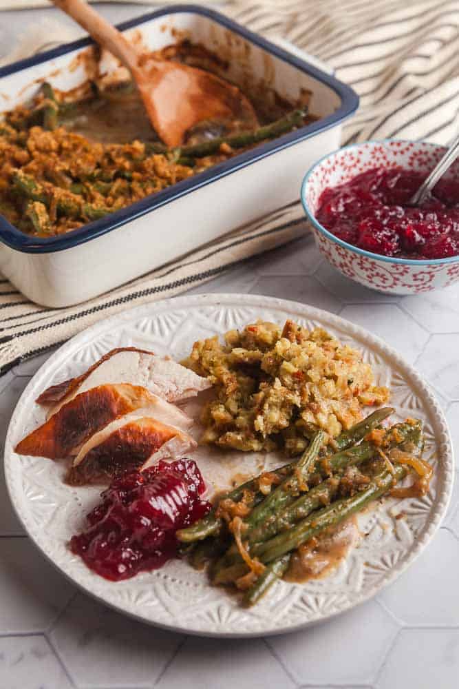 plated chicken dinner with stuffing, healthy green bean casserole, and cranberries