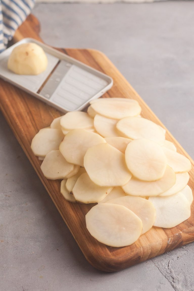 Using a mandoline to slice the potatoes very thin