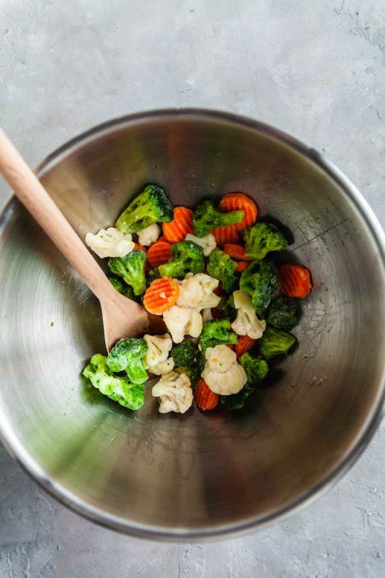 Mixing frozen vegetables and oil in a large bowl. 