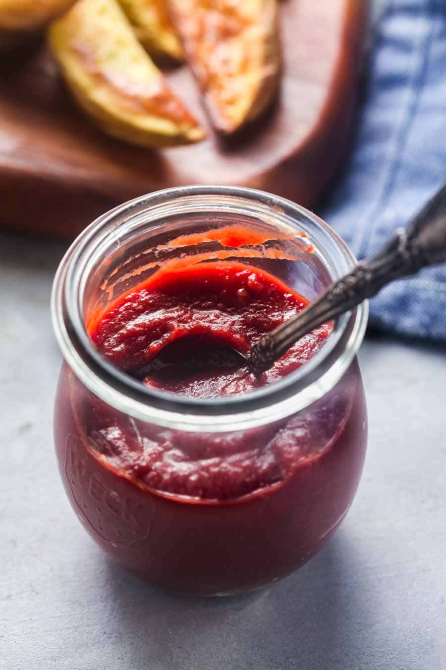 A small glass jar filled with homemade paleo ketchup. 