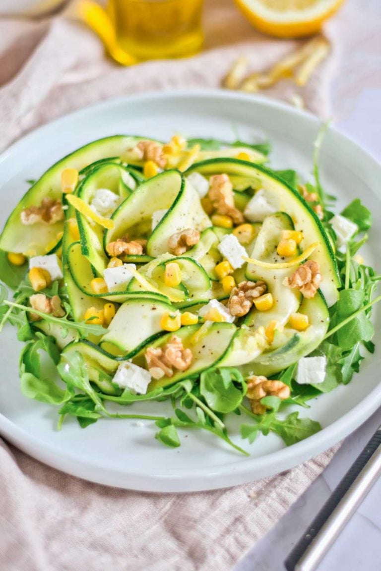 A closeup view of zucchini and corn salad with walnuts and feta. 