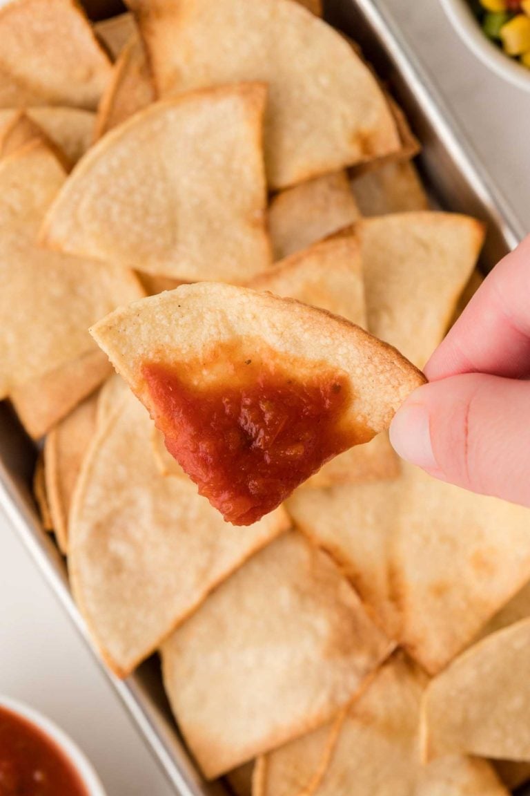 A close-up view of a super crispy air fryer tortilla chip with salsa.  