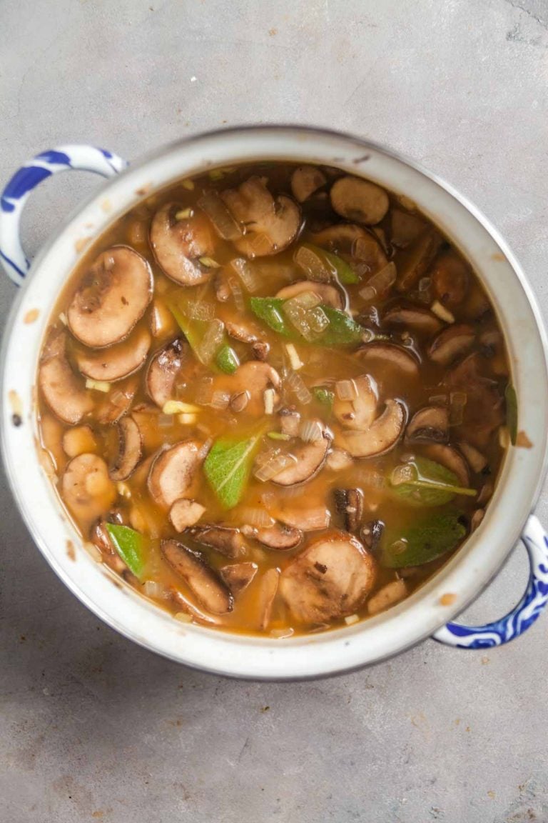 Simmering mushrooms, onions, and herbs to make vegetarian gravy.