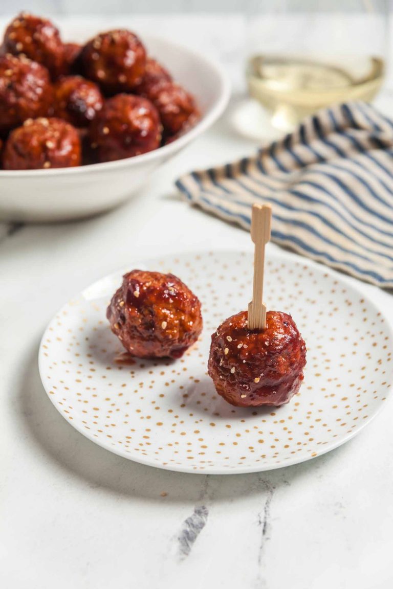 Two cranberry chili meatballs on an appetizer plate.