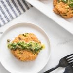 vertical image of salmon patties on white plate with forks