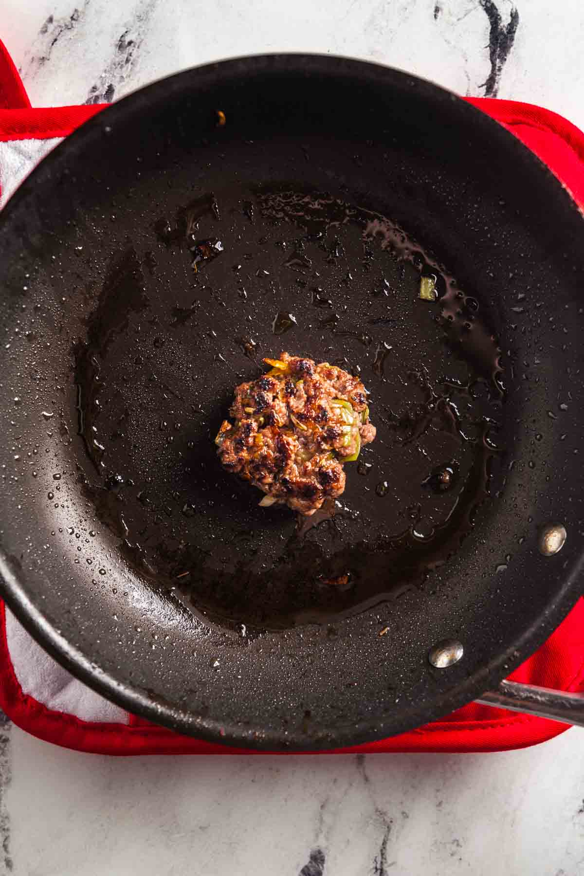 Frying off a small portion of sausage to test the seasoning.