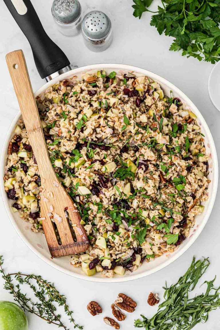 Overhead view of a pan of vegetarian rice pilaf with cranberries and fresh herbs, 