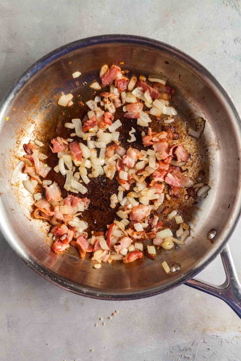 Overhead view of sauteeing bacon and onions to make this delicious kapusta recipe.