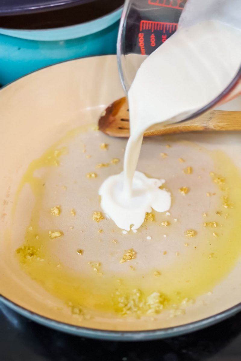 Adding heavy cream to sauteed garlic. 