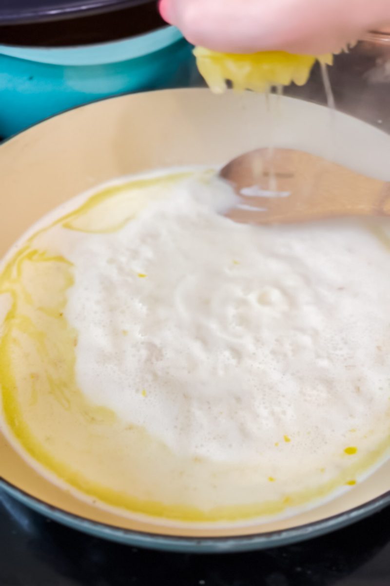 Stirring in lemon juice to make a cream sauce for salmon pasta. 