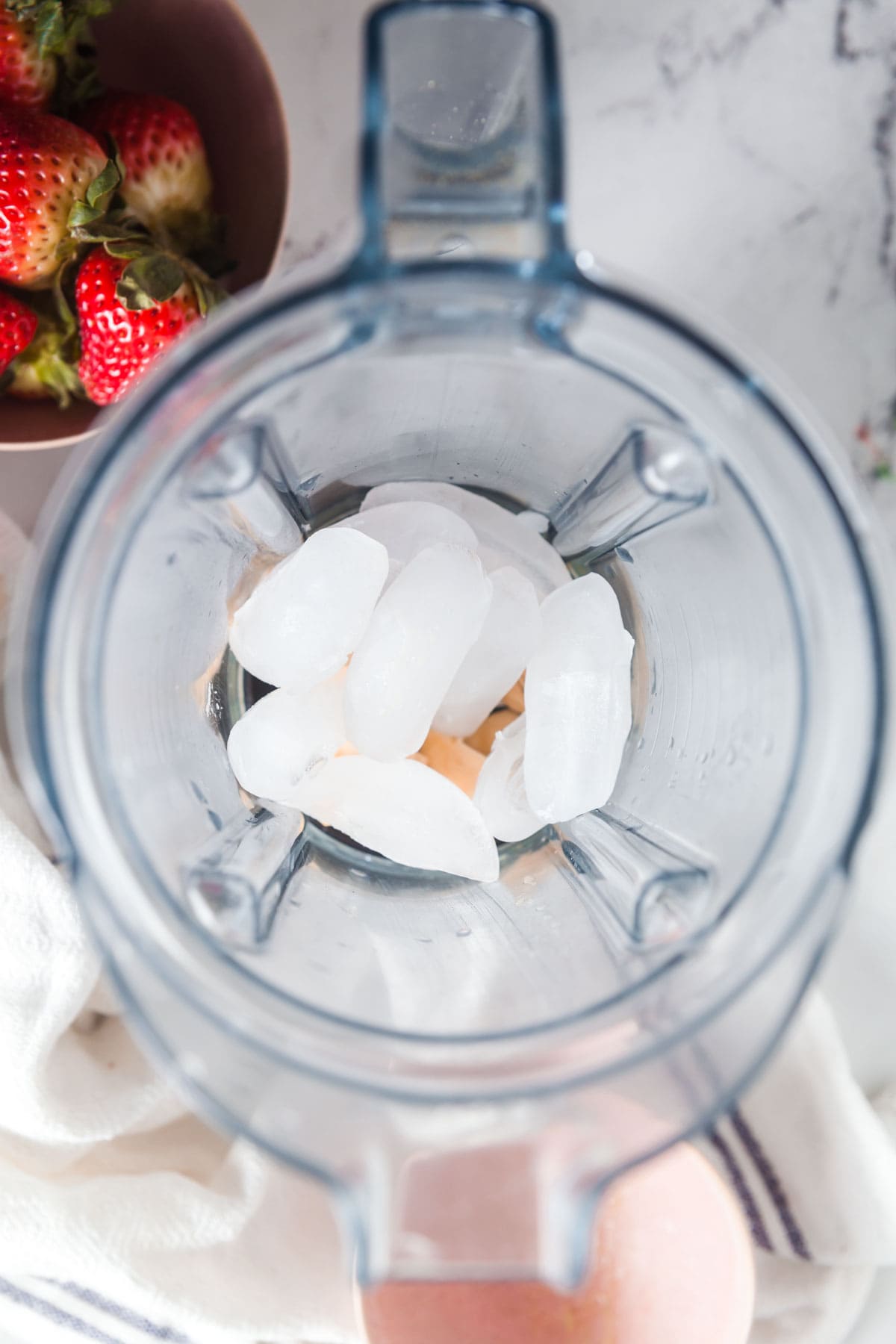 Adding ice to the blender to give this homemade smoothie a dozen, frothy texture like a daiquiri. 