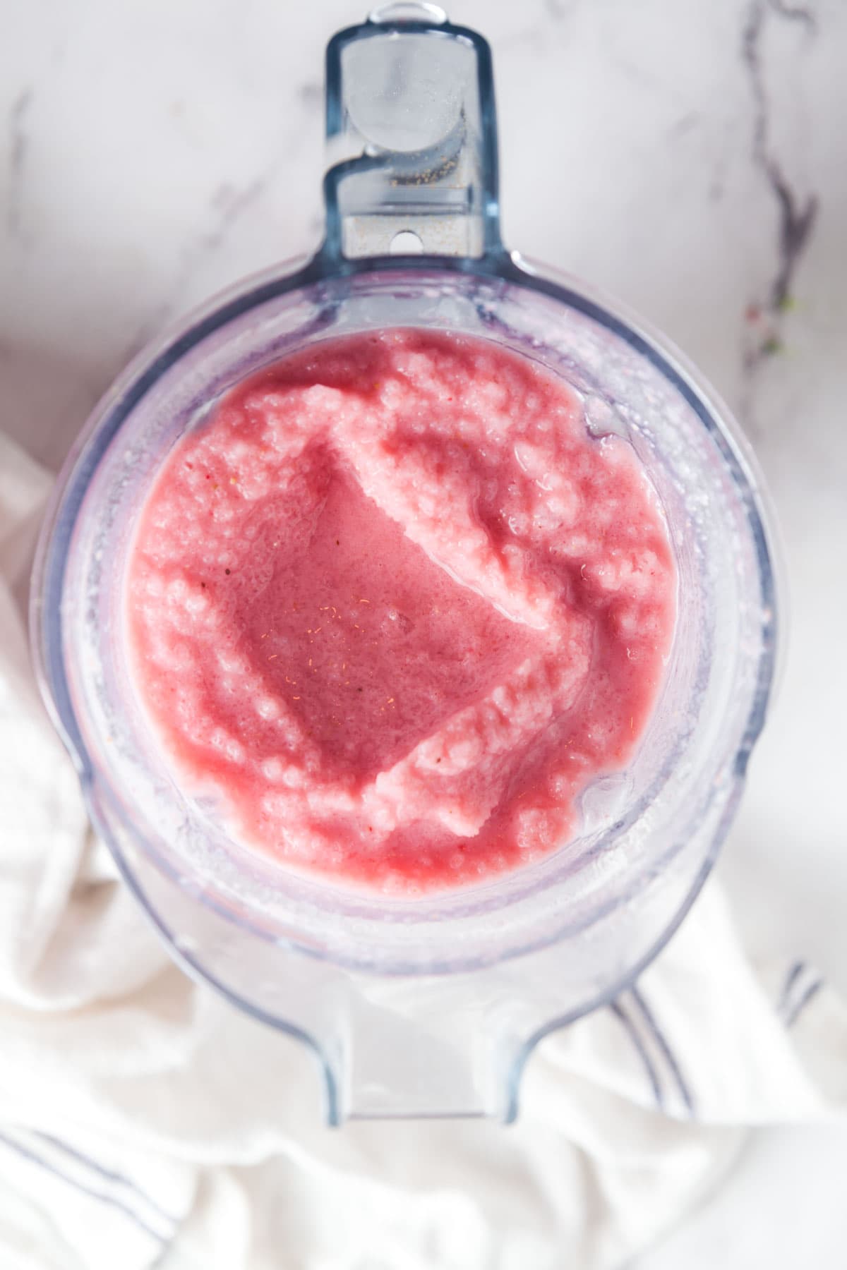 Overhead view of a blender filled with strawberry banana smoothie. 