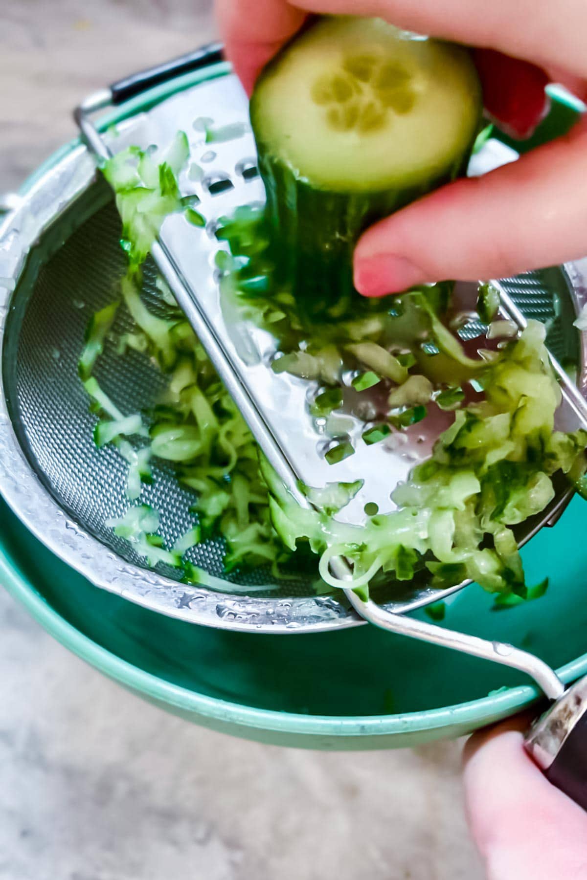 Step by step photos of how to make tzatziki sauce: Grating a cucumber.