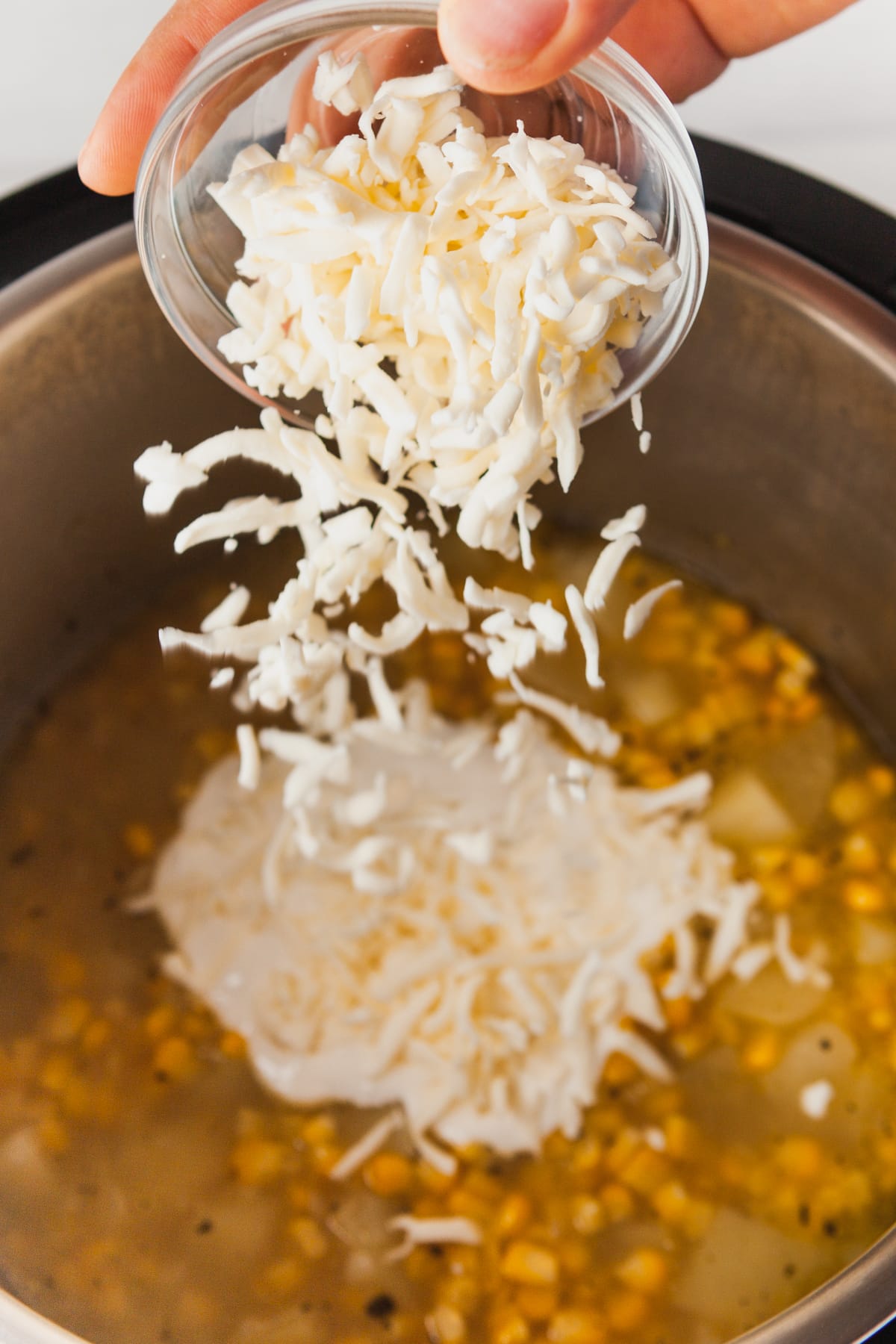Stirring sour cream and cheese into the cooked soup before blending. 