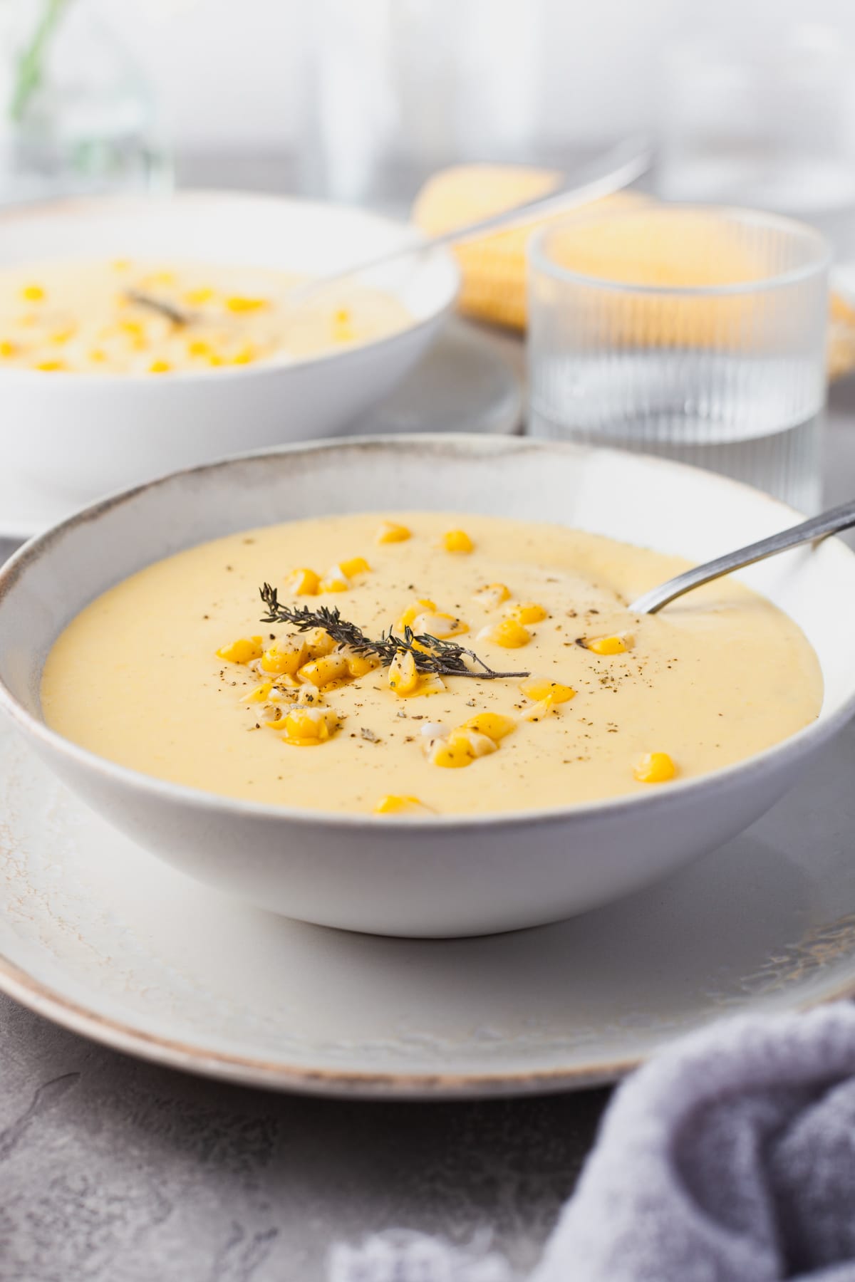 Two bowl of creamy corn soup on a table. 