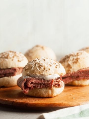 Beef on Weck sliders on a wooden board.