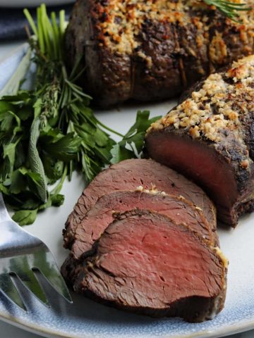 Sliced oven roast beef tenderloin on a platter.