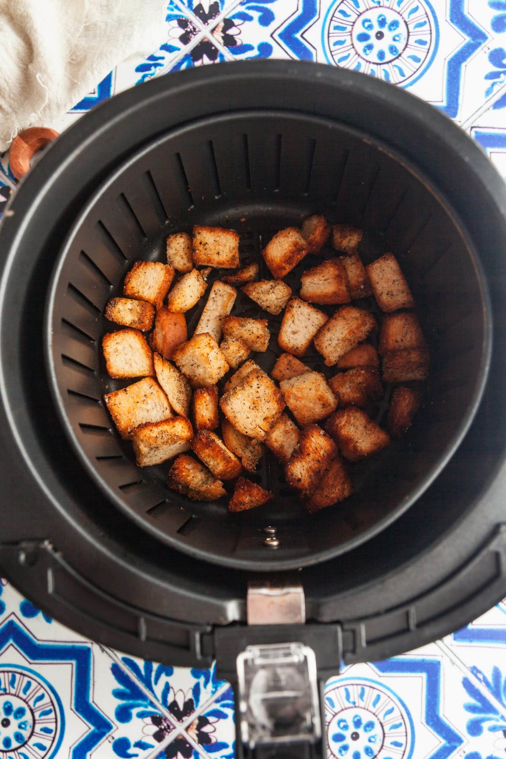 Croutons in the air fryer basket.
