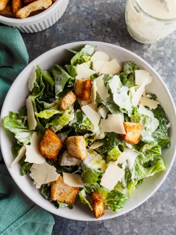 Overhead view of a caeser salad with sourdough croutons, parmesan cheese, and romaine ltetuce.