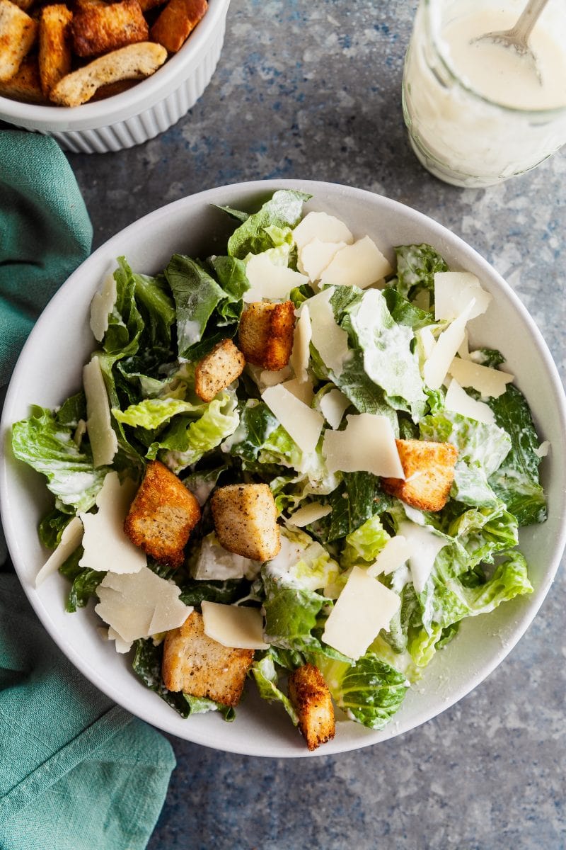Overhead view of a caeser salad with sourdough croutons, parmesan cheese, and romaine ltetuce.