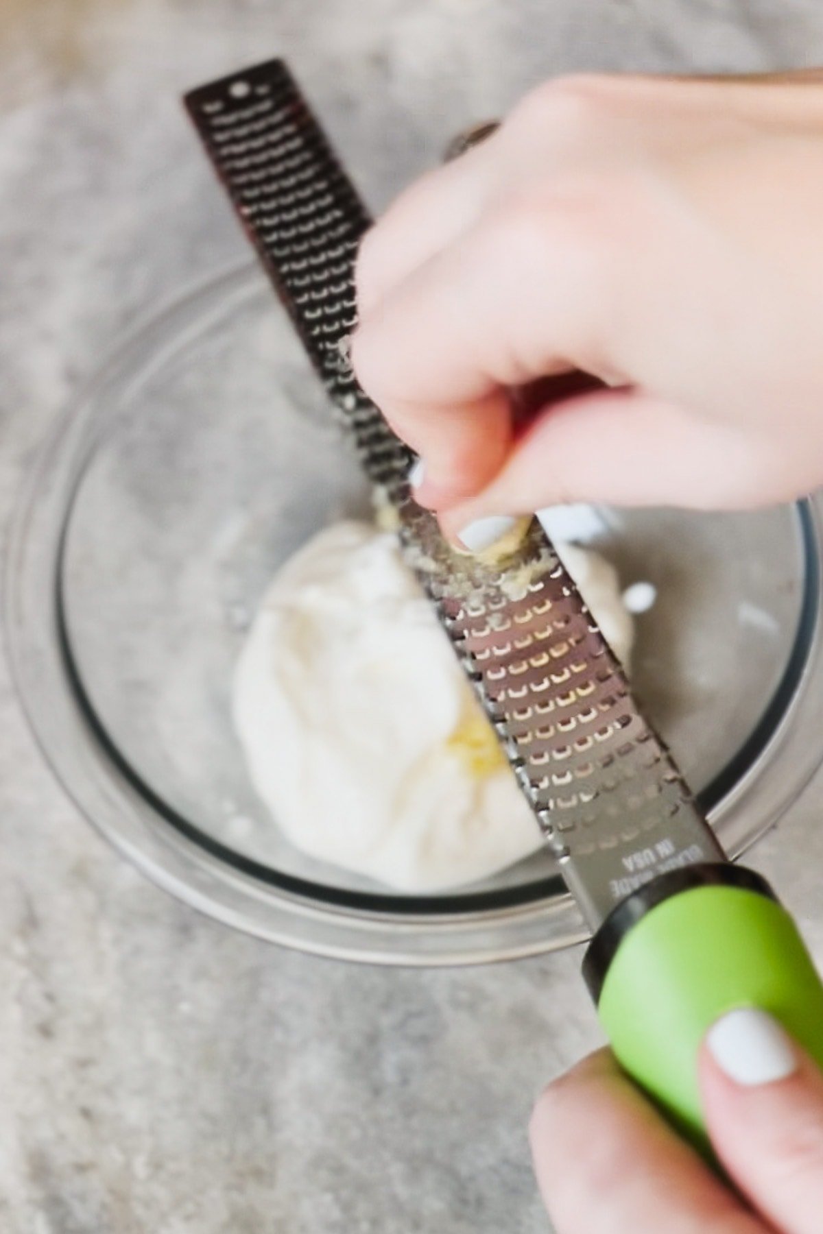 Grating garlic with a microplane grater.