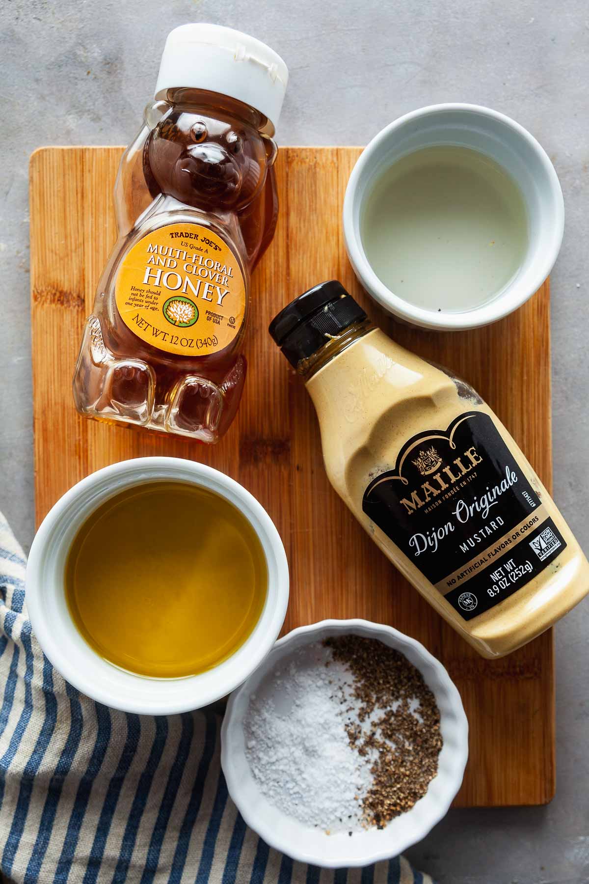 Ingredients needed to make a simple vinaigrette dressing, including honey and mustard. 