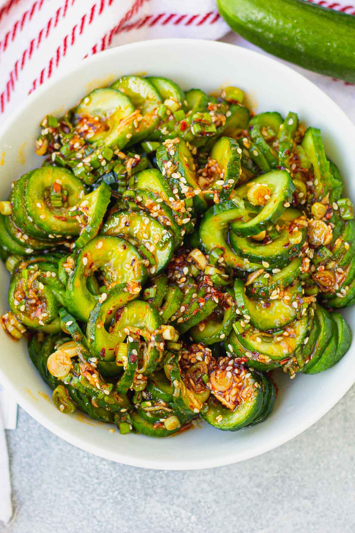 Overhead view of Korean cucumber salad in a white bowl. 