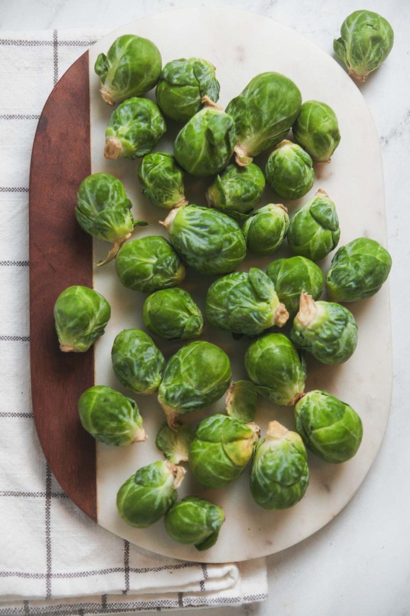 Whole Brussels Sprouts on a marble board. 